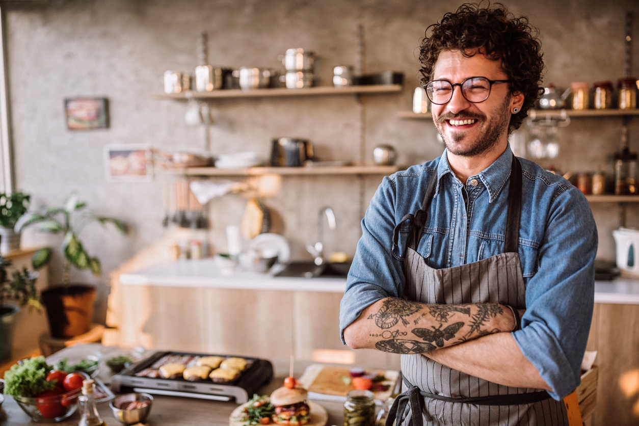 Portrait of chef in the kitchen standing and looking at camera, arms crossed