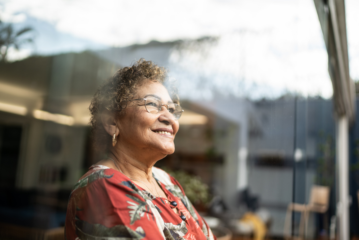 Happy senior woman contemplating at home